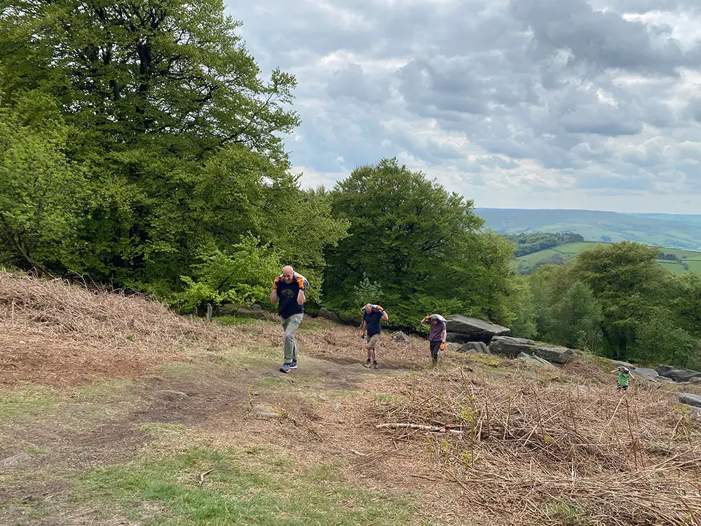 Volunteers carry sacks uphill to Stanage Plantation
